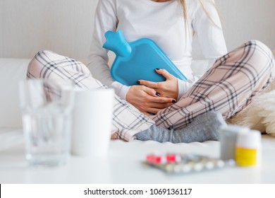 Woman With Hot Water Bottle Healing Stomach Pain