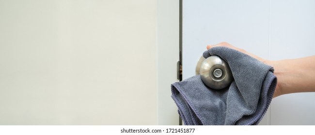 Woman House Keeper Cleaning A Dirty Stainless Door Knob In Toilet. Maid Spraying Liquid Cleaning Solution On The Dirty Door Knob Handle In Toilet And Using Micro Fabric Wipe On Door Knob Surface.