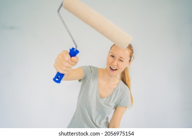 Woman House Painter Worker Painting And Priming Wall With Painting Roller. DIY