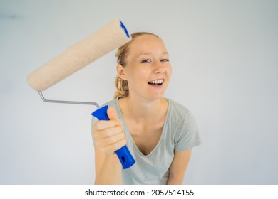 Woman House Painter Worker Painting And Priming Wall With Painting Roller. DIY