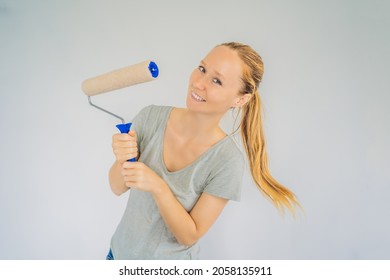 Woman House Painter Worker Painting And Priming Wall With Painting Roller. DIY