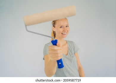 Woman House Painter Worker Painting And Priming Wall With Painting Roller. DIY