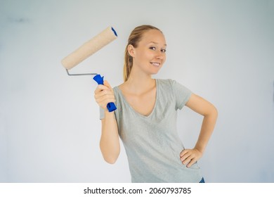 Woman House Painter Worker Painting And Priming Wall With Painting Roller. DIY