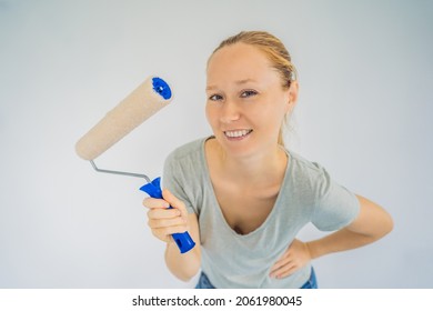 Woman House Painter Worker Painting And Priming Wall With Painting Roller. DIY