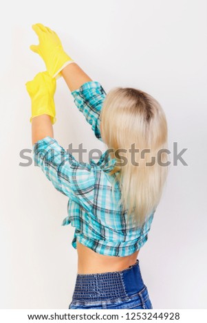 woman housekeeper wear yellow rubber gloves on white background back view