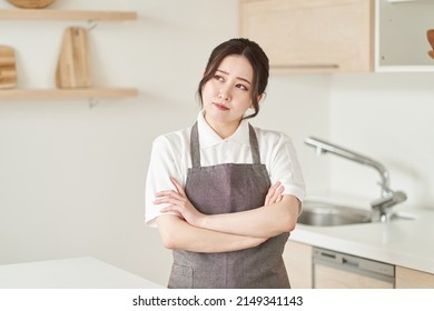 A Woman In The Housekeeping Business Who Crosses Her Arms And Thinks