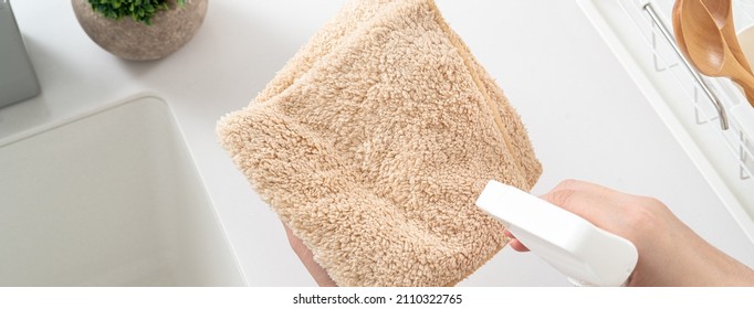 Woman Housewife Is Doing The Spring Cleaning At Home Kitchen With Using Rag, Spraying Bottle Cleaner To Wipe The Counter Table Surface.