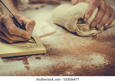 Woman housewife writes a recipe on paper and pressing dough - Powered by Shutterstock