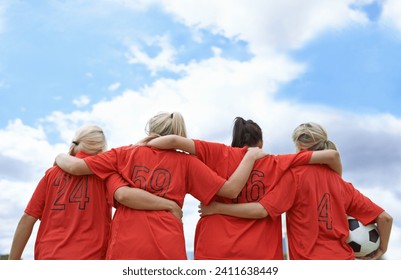 Woman, hug and back of soccer team ready for sports match, game or outdoor practice with blue sky. Rear view of female person or group of football players standing in unity with ball in nature - Powered by Shutterstock