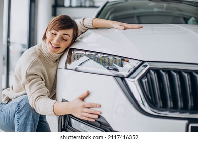 Woman Hugging Car In A Car Showroom