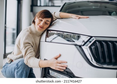 Woman Hugging Car In A Car Showroom