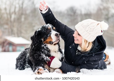 Woman Hugging Her Dog In The Snow On Winter Day