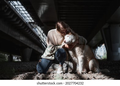 Woman Hugging Her Husky Dog In An Urban Big City Location Under An Bridge Or Overpass. Lost And Found Pets. 