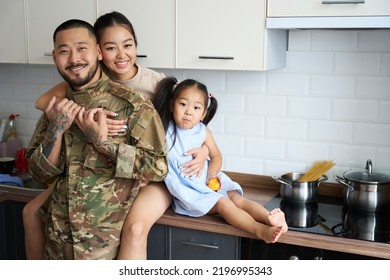 Woman hugging her military husband and little daughter