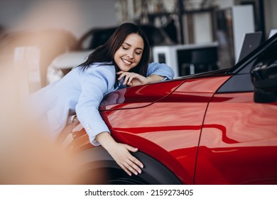 Woman hugging her new red car