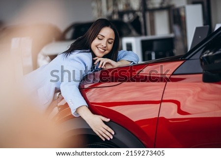 Woman hugging her new red car