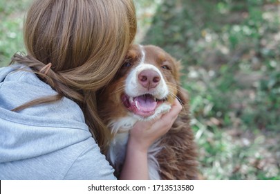 A Woman Hugs And Kisses A Dog, A Girl And A Dog, An Australian Shepherd With A Man