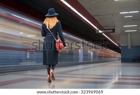 Woman in a hurry to walk the modern subway station tunnels