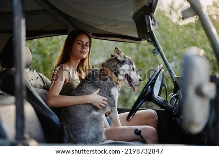 Woman and husky dog happily traveling in car smile with teeth fall walk with pet, travel with dog friend hugs and dances
