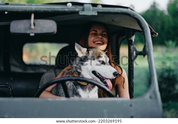 Woman\
and husky dog happily traveling in car smile with teeth fall walk\
with pet, travel with dog friend hugs and\
dances