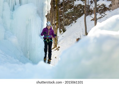 Woman Ice Climber Tying A Rope To His Harness, Preparing For A Climb