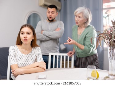 Woman ignoring her husband and mother-in-law standing behind and arguing with her at home. - Shutterstock ID 2161857085
