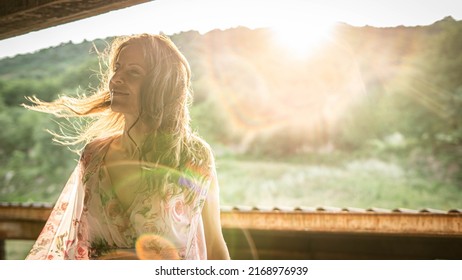 Woman Illuminated By The Last Rays Of Sun And A Gentle Wind Shows Pleasant Expression