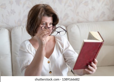 Woman With Impaired Vision Reading A Book Through Two Glasses