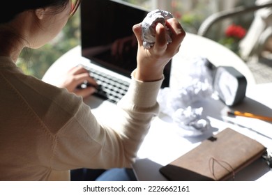 A woman with an impending deadline is crumpling a piece of paper in anger - Shutterstock ID 2226662161