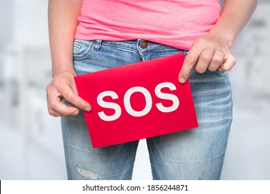 Woman with incontinence problem with SOS on paper - urinary incontinence concept