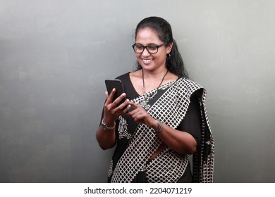 Woman Of Indian Ethnicity Looking At Mobile Phone With An Excited Face 