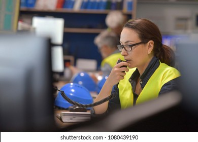 Woman In Industrial Control Room Using Radio To Give Instructions