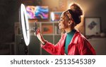 Woman, influencer and phone with ring light for video recording, vlogging or online tutorial at home. Young, female person or vlogger setting up mobile smartphone for advice, tips or content creation