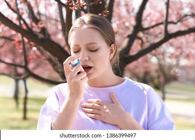 Woman With Inhaler Having Asthma Attack On Spring Day