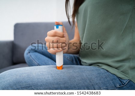 Woman Injecting Epinephrine Using Auto-injector Syringe As An Emergency Treatment For Allergic Reaction