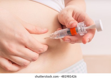 Woman Is Injecting Hormones To Belly With Syringe. IVF Concept.