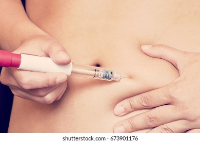 Woman Is Injecting Hormones To Belly With Syringe. IVF Concept.