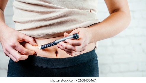 A Woman Injects Insulin With Insulin Injection Device Into The Subcutaneous Tissue Of Abdomen