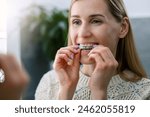 woman inserting transparent invisible dental aligners for crooked teeth straightening