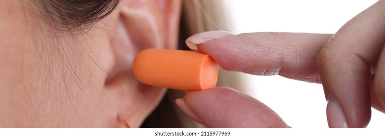 Woman Inserts Orange Earplugs Into Ears. Types Of Sleep Ear Plugs Concept