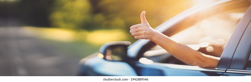 Woman inside her car gesticulate thumb up - Shutterstock ID 1941889546
