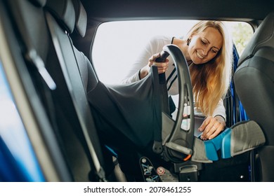 Woman Installing Baby Car Seat Into Her Car