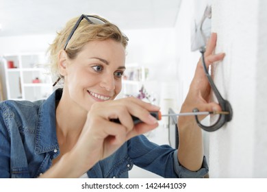 Woman Installing A Hook On The Wall