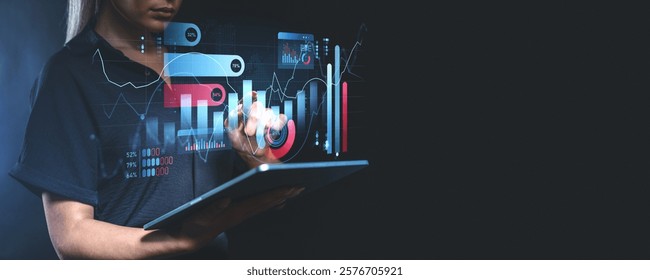 Woman interacting with futuristic digital charts and graphs, with data visualization overlays. Dark blurred background. Concept of finance