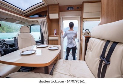 Woman in the interior of a camper RV motorhome with a cup of coffee looking at nature. - Shutterstock ID 1470798161