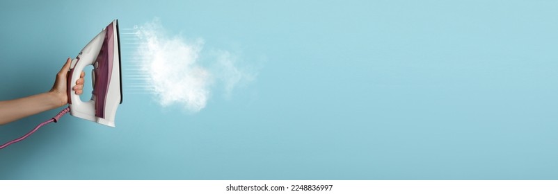 Woman with iron on light blue background, closeup. Banner design with space for text