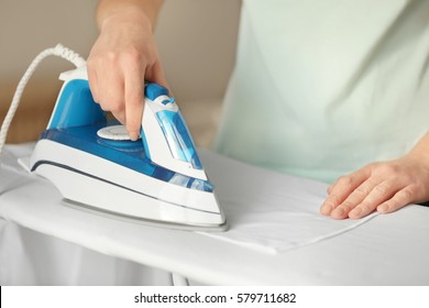 Woman Ironing Cloth On Board, Closeup