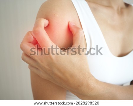 A woman with itching scratching her shoulder skin caused by eczema, allergic skin, dermatitis and insect bites. closeup photo, blurred.