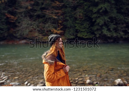 woman in a jacket with a hat near the river                     