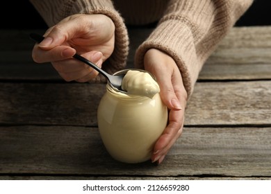 Woman With Jar Of Delicious Mayonnaise At Wooden Table, Closeup